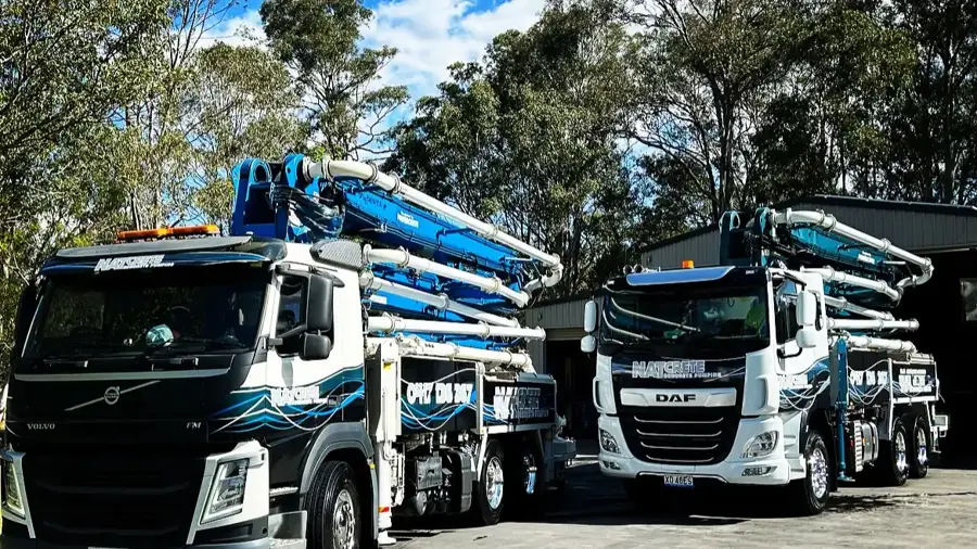 Natcrete's two 36m concrete boom pump trucks parked side by side at the depot